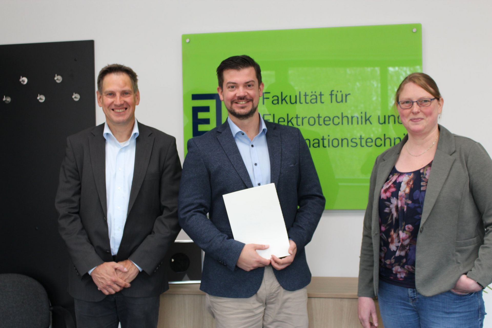 Dr. Christoph Baer (Mitte) wurde am 04.04.2022 zum Akademischen Oberrat ernannt. Überreicht wurde die Urkunde von Dekan Prof. Dr. Thomas Musch (l.) und Geschäftsführerin Dr. Corinna Heldt (r.) (© RUB/Zeitel)